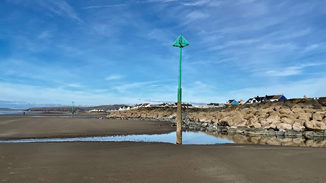 A sandy beach with a turquoise beacon