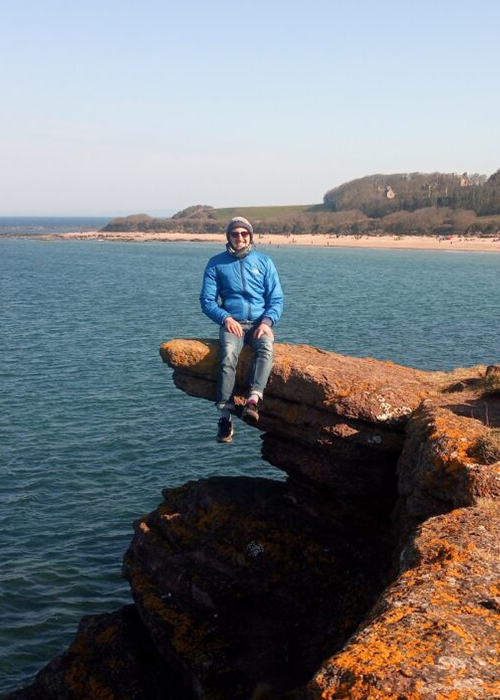 James Robinson RACC James Robinson sits on a rocky outcrop by the sea