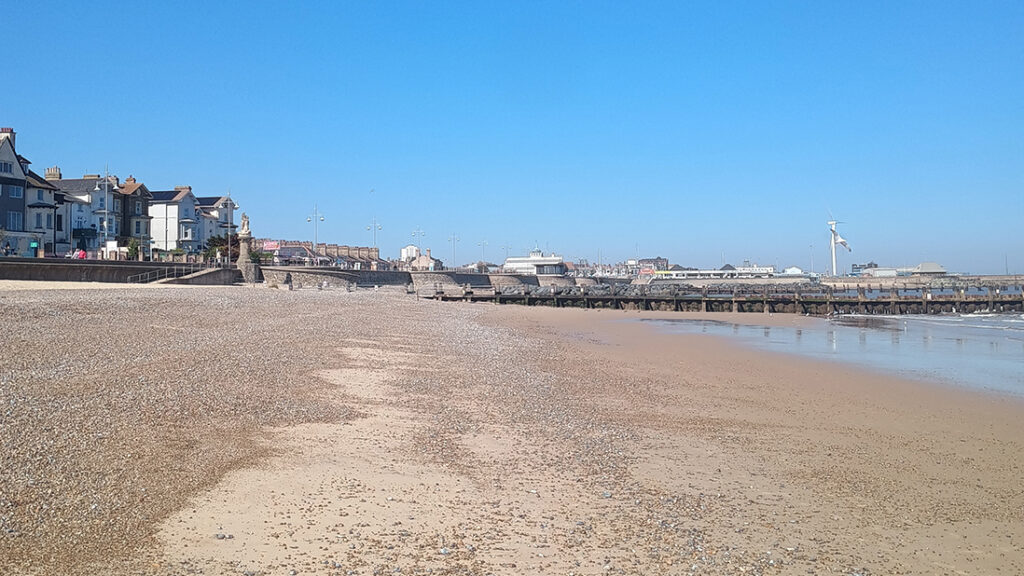 A sloping beach with town in the distance